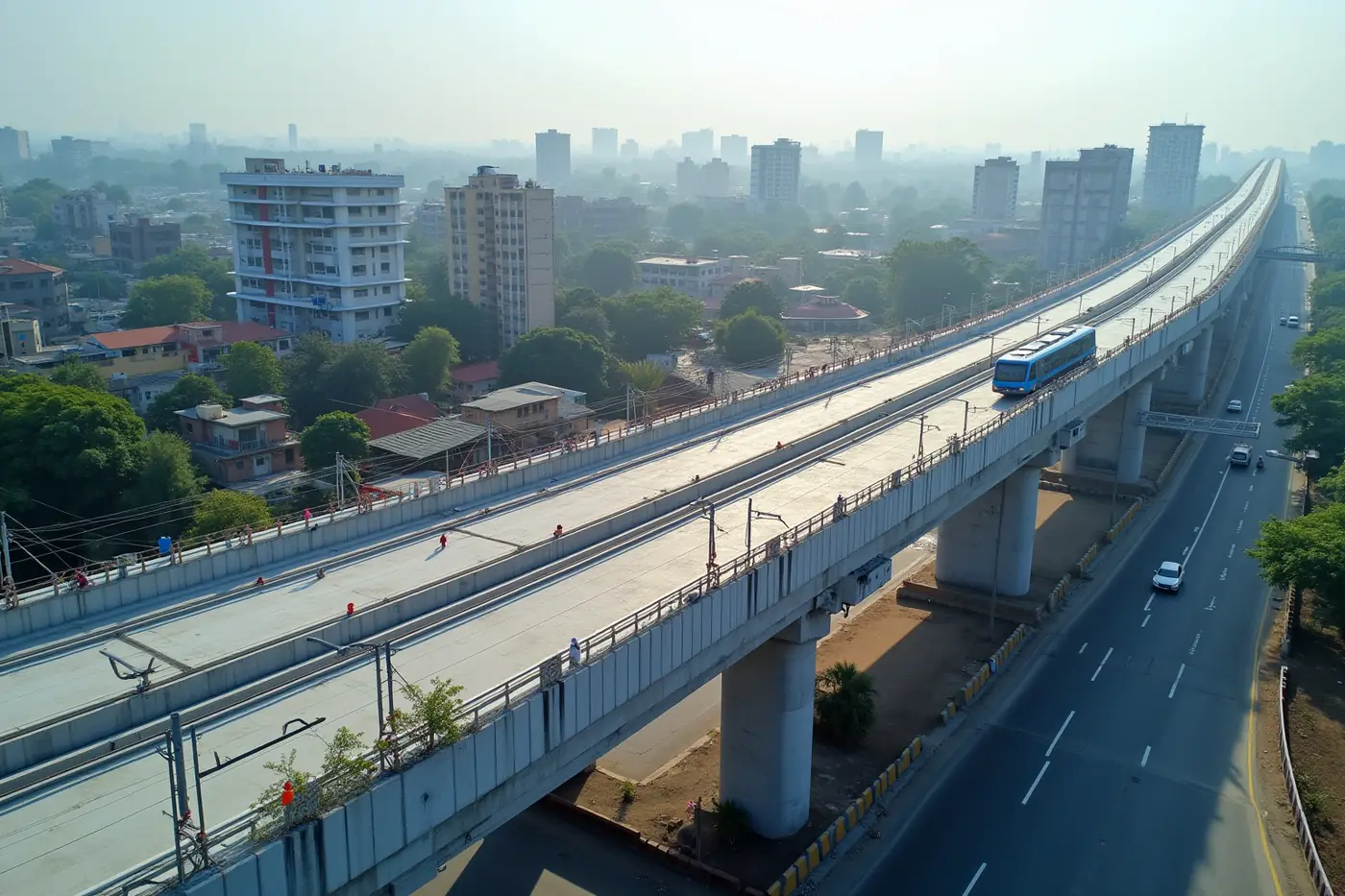 Aerial view of an elevated metro rail viaduct under construction over a wide city arterial road
